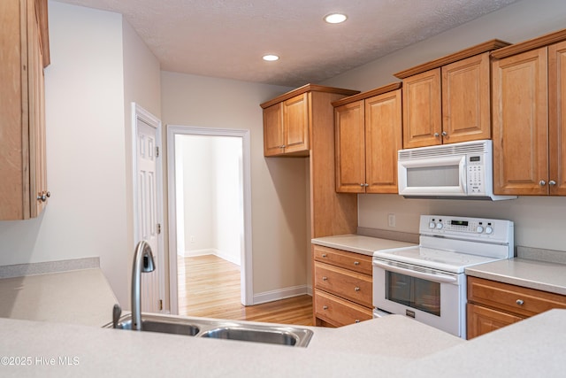 114 Baker Cir W, End, NC 27376 - kitchen with white appliances, a sink, light wood finished floors, light countertops, and recessed lighting