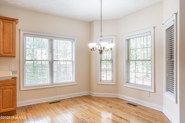 114 Baker Cir W, End, NC 27376 - unfurnished dining area with a chandelier, light wood-style floors, and plenty of natural light