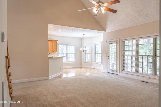 114 Baker Cir W, End, NC 27376 - unfurnished living room with light colored carpet, a chandelier, ceiling fan, baseboards, and high vaulted ceiling