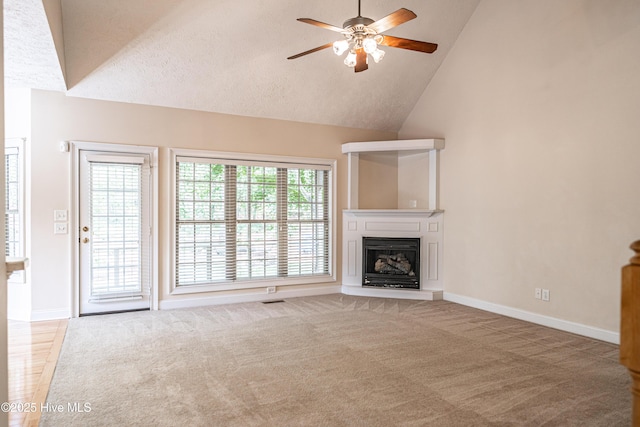114 Baker Cir W, End, NC 27376 - unfurnished living room featuring ceiling fan, carpet flooring, baseboards, a fireplace with raised hearth, and high vaulted ceiling