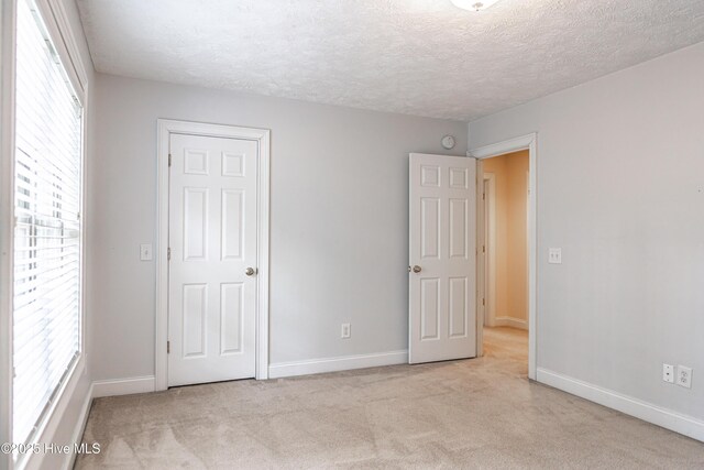 114 Baker Cir W, End, NC 27376 - unfurnished bedroom featuring carpet floors, a textured ceiling, and baseboards