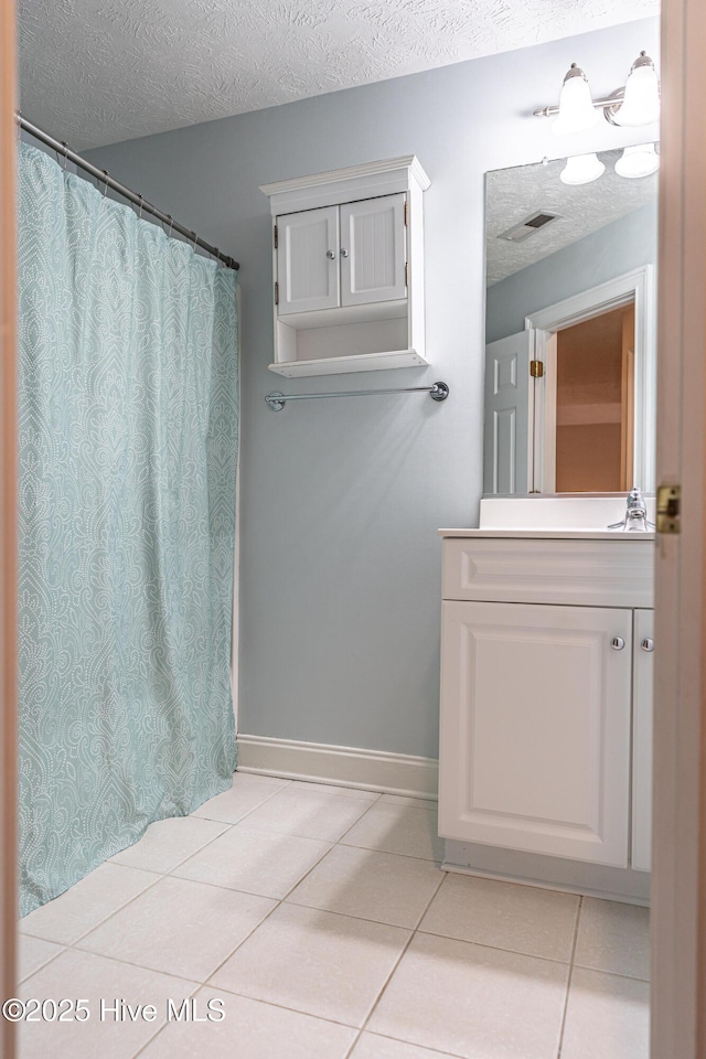 114 Baker Cir W, End, NC 27376 - full bathroom featuring tile patterned flooring, a textured ceiling, vanity, baseboards, and curtained shower