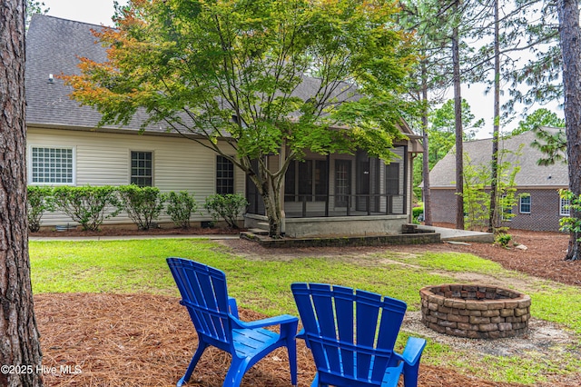 114 Baker Cir W, End, NC 27376 - back of house featuring an outdoor fire pit, a sunroom, a shingled roof, and a lawn
