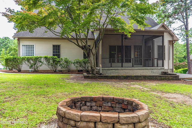 114 Baker Cir W, End, NC 27376 - back of property with a fire pit, a sunroom, roof with shingles, and a lawn
