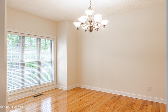 114 Baker Cir W, End, NC 27376 - unfurnished room with a chandelier, baseboards, and light wood-type flooring