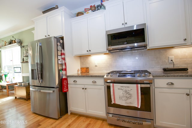 305 3rd St, Aberdeen, NC 28315 - kitchen with appliances with stainless steel finishes, white cabinetry, light wood-style flooring, and crown molding