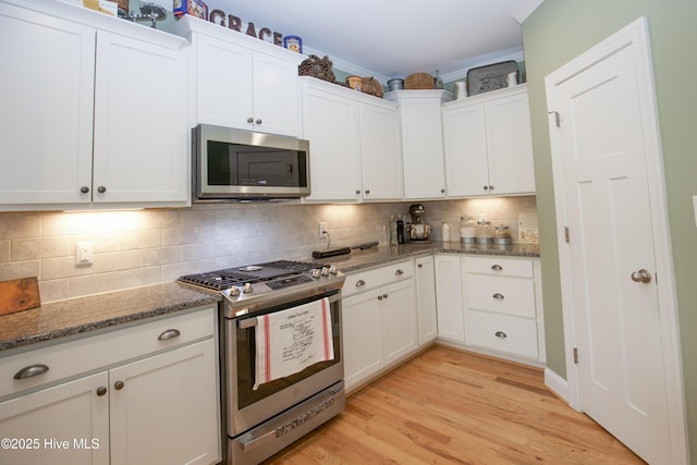 305 3rd St, Aberdeen, NC 28315 - kitchen featuring appliances with stainless steel finishes, white cabinets, stone counters, and decorative backsplash