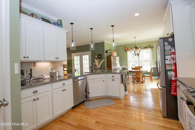 305 3rd St, Aberdeen, NC 28315 - kitchen featuring stainless steel appliances, a sink, white cabinetry, a chandelier, and ornamental molding