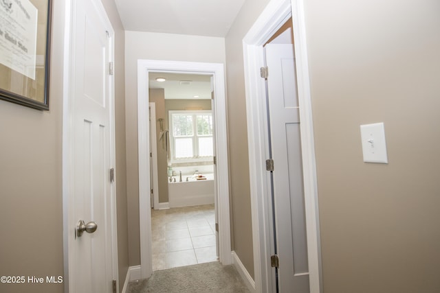 305 3rd St, Aberdeen, NC 28315 - hallway with light colored carpet, baseboards, and light tile patterned flooring