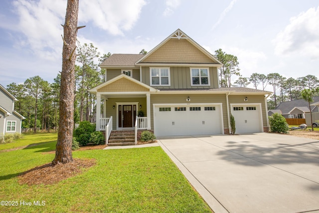 305 3rd St, Aberdeen, NC 28315 - craftsman-style house featuring board and batten siding, driveway, a porch, a front lawn, and a garage