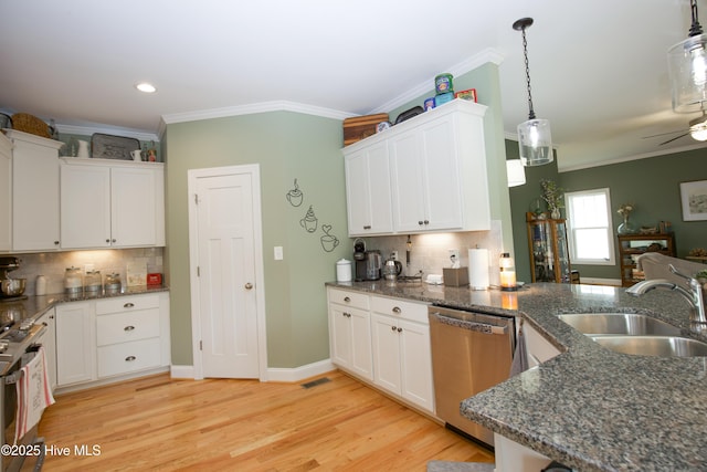 305 3rd St, Aberdeen, NC 28315 - kitchen with stainless steel appliances, a sink, crown molding, white cabinets, and backsplash