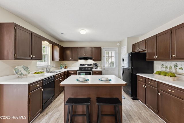 1415 Setter Ct, Wilmington, NC 28411 - kitchen with black appliances, extractor fan, a sink, a center island, and healthy amount of natural light