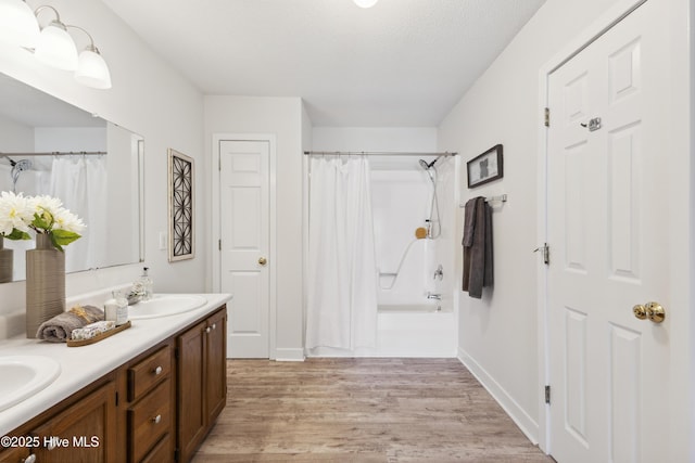 1415 Setter Ct, Wilmington, NC 28411 - full bathroom with double vanity, wood finished floors, shower / bath combo, and baseboards