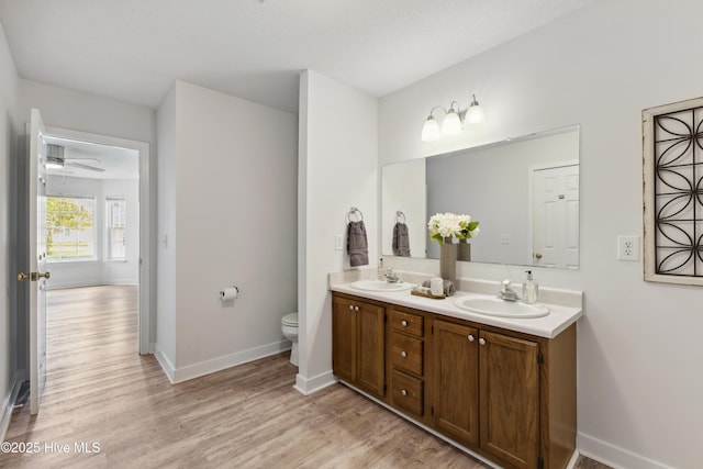 1415 Setter Ct, Wilmington, NC 28411 - full bath featuring wood finished floors, double vanity, toilet, and baseboards