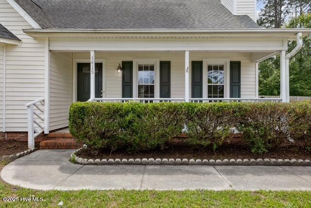 1415 Setter Ct, Wilmington, NC 28411 - doorway to property featuring a porch, a chimney, and roof with shingles