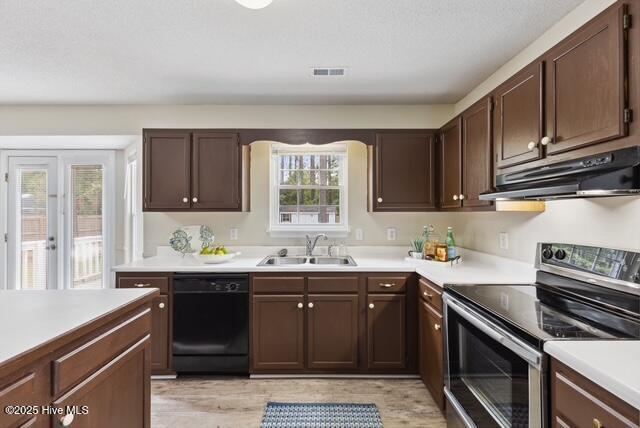 1415 Setter Ct, Wilmington, NC 28411 - kitchen with black dishwasher, stainless steel range with electric stovetop, under cabinet range hood, a sink, and light wood-style flooring
