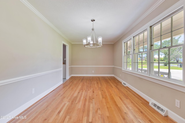 spare room with a chandelier, ornamental molding, baseboards, and light wood-type flooring