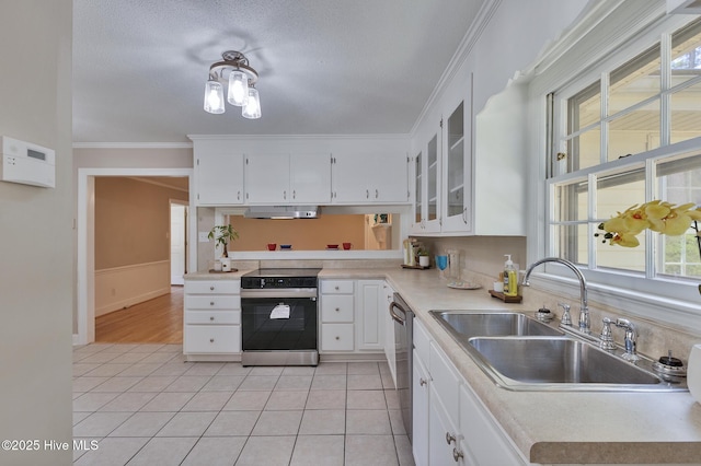 kitchen with electric stove, under cabinet range hood, a sink, ornamental molding, and light tile patterned flooring