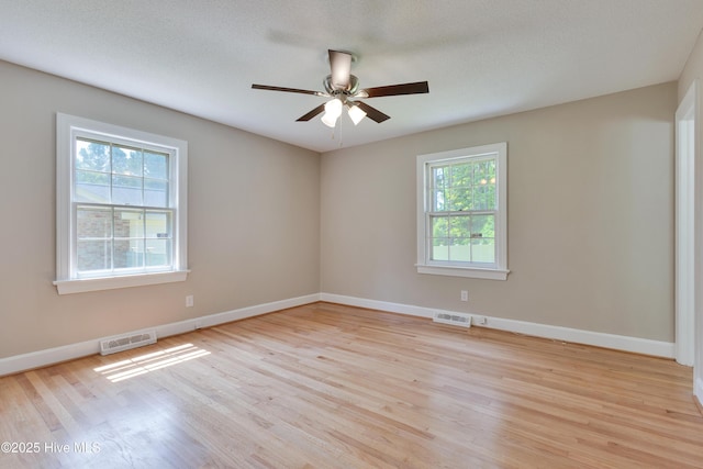 empty room with light wood finished floors, ceiling fan, and baseboards
