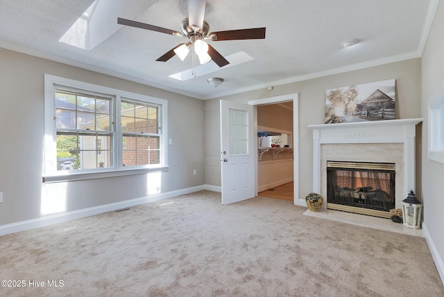 unfurnished living room featuring a ceiling fan, carpet, crown molding, a premium fireplace, and a textured ceiling