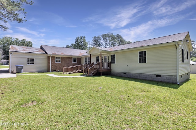 rear view of house with crawl space and a yard