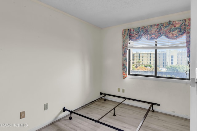 2306 W Fort Macon Rd Unit 209H, Atlantic Beach, NC 28512 - empty room with wood finished floors, crown molding, a textured ceiling, and baseboards