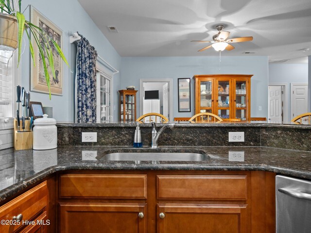 211 Brook Crossing Rd, Swansboro, NC 28584 - kitchen featuring dishwasher, brown cabinetry, a ceiling fan, and dark stone counters