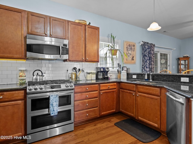 211 Brook Crossing Rd, Swansboro, NC 28584 - kitchen featuring appliances with stainless steel finishes, wood finished floors, and brown cabinets