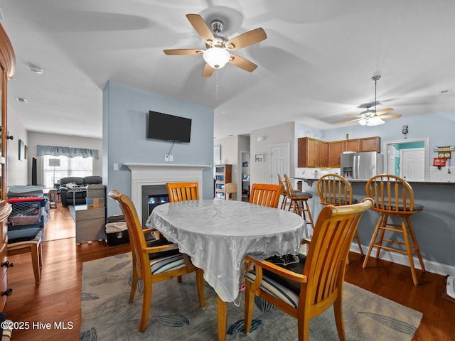 211 Brook Crossing Rd, Swansboro, NC 28584 - dining room featuring ceiling fan, a glass covered fireplace, and wood finished floors