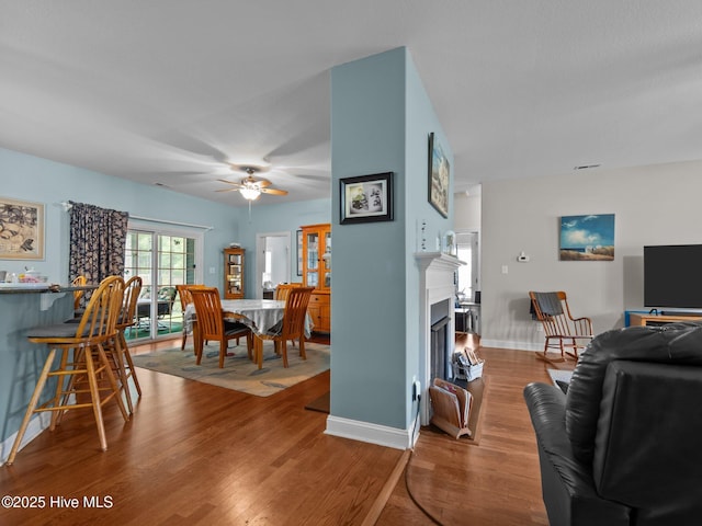 211 Brook Crossing Rd, Swansboro, NC 28584 - living room featuring wood finished floors, a ceiling fan, and a fireplace
