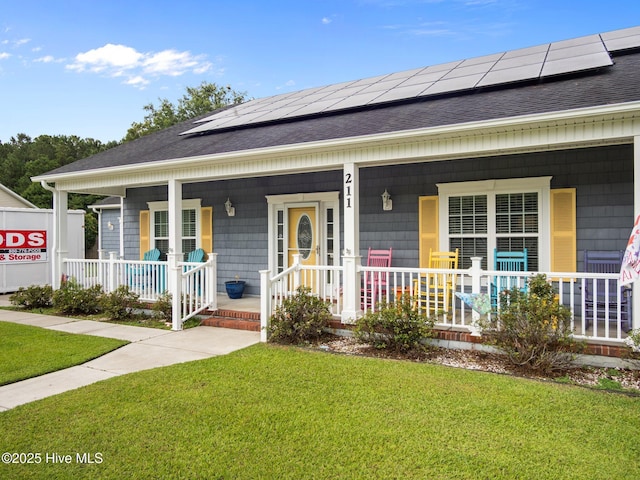 211 Brook Crossing Rd, Swansboro, NC 28584 - view of front of house with covered porch, a shingled roof, a front lawn, and solar panels
