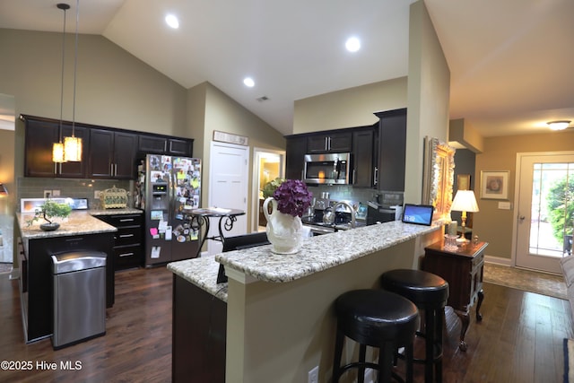 275 Pinehurst Trace Dr, Pinehurst, NC 28374 - kitchen with appliances with stainless steel finishes, a peninsula, tasteful backsplash, a breakfast bar area, and high vaulted ceiling