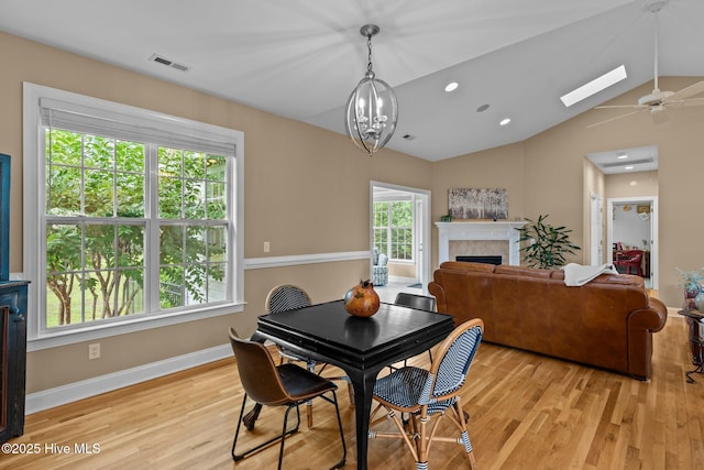 3101 Redfield Dr, Leland, NC 28451 - dining area featuring light wood-type flooring, a fireplace, vaulted ceiling, a skylight, and baseboards