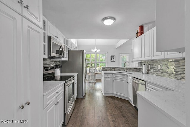 105 Sea Turtle Cv, Sneads Ferry, NC 28460 - kitchen with stainless steel appliances, a sink, white cabinets, a chandelier, and decorative backsplash