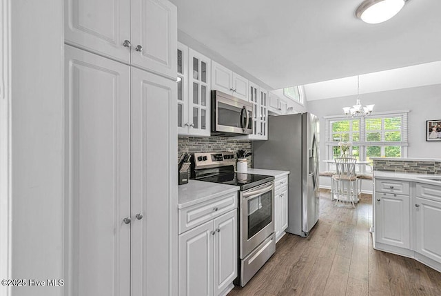 105 Sea Turtle Cv, Sneads Ferry, NC 28460 - kitchen featuring stainless steel appliances, white cabinets, a chandelier, light countertops, and backsplash