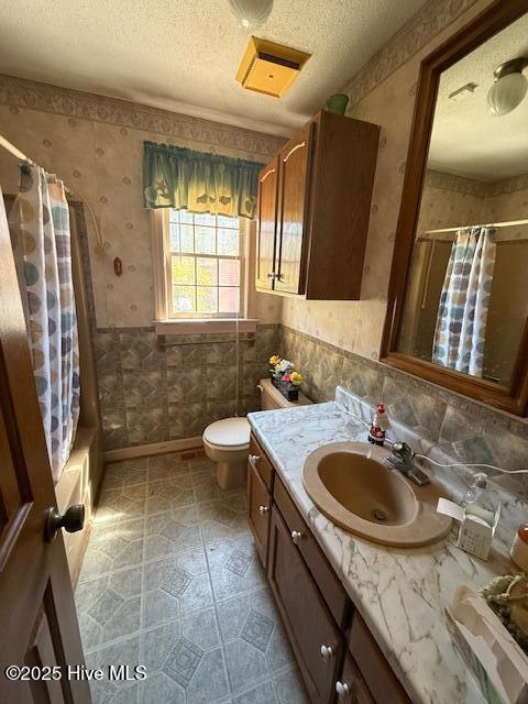 1164 Ocean Hwy N, Hertford, NC 27944 - bathroom with wallpapered walls, vanity, a textured ceiling, toilet, and shower / tub combo