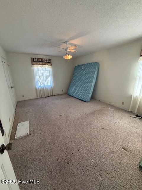 1164 Ocean Hwy N, Hertford, NC 27944 - carpeted empty room featuring a textured ceiling and ceiling fan