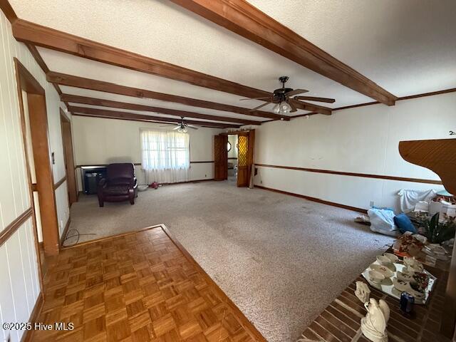 1164 Ocean Hwy N, Hertford, NC 27944 - unfurnished living room featuring a ceiling fan, beam ceiling, and baseboards