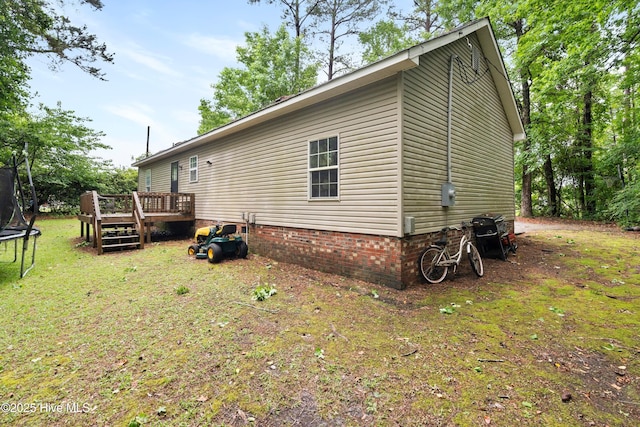 330 Brookfield Dr, Wilmington, NC 28405 - view of side of home featuring a trampoline, a deck, and a lawn