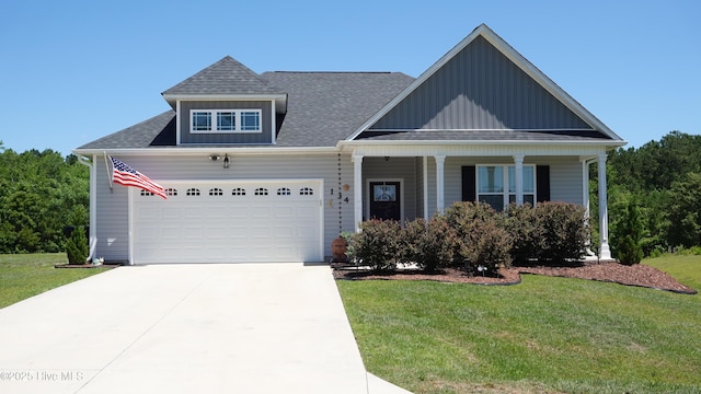 134 Longhorn Rd, Jacksonville, NC 28546 - view of front facade featuring a front lawn, an attached garage, board and batten siding, covered porch, and concrete driveway