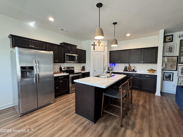 134 Longhorn Rd, Jacksonville, NC 28546 - kitchen featuring appliances with stainless steel finishes, a sink, wood finished floors, light countertops, and a textured ceiling