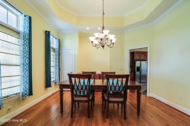 1711 Heather Run Ct SE, Bolivia, NC 28422 - dining space with a raised ceiling, dark wood-style floors, a chandelier, baseboards, and crown molding