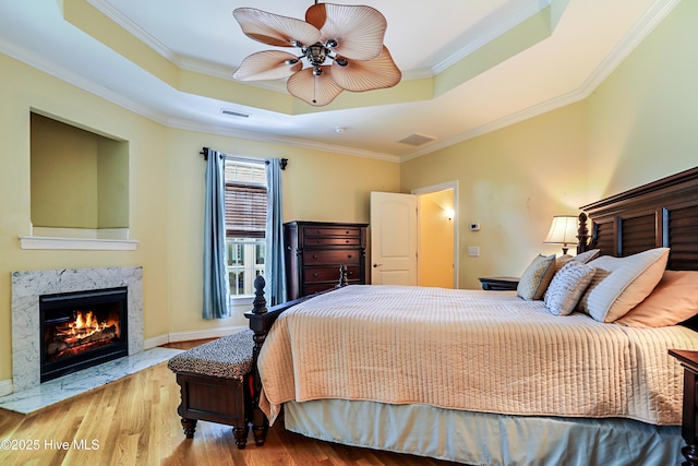 1711 Heather Run Ct SE, Bolivia, NC 28422 - bedroom with a raised ceiling, wood finished floors, a high end fireplace, ornamental molding, and a ceiling fan