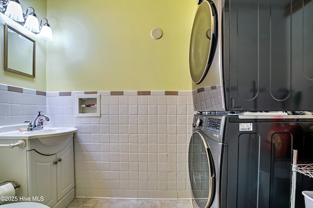 1711 Heather Run Ct SE, Bolivia, NC 28422 - bathroom featuring stacked washer and clothes dryer, vanity, tile walls, and wainscoting