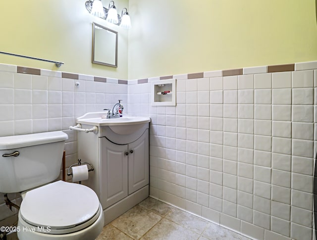 1711 Heather Run Ct SE, Bolivia, NC 28422 - bathroom with vanity, tile walls, toilet, and wainscoting