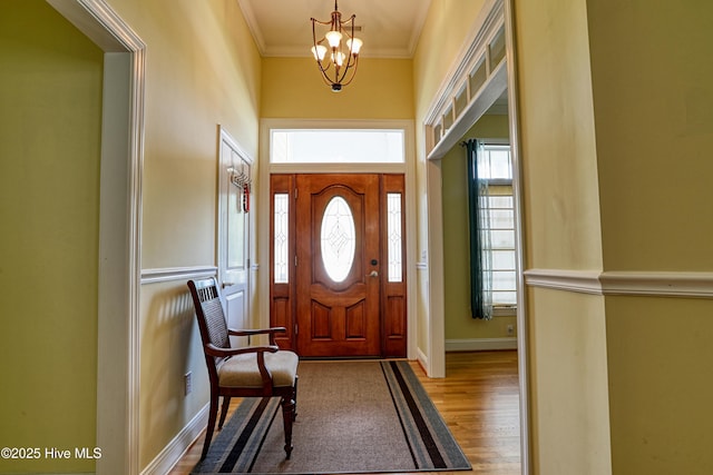 1711 Heather Run Ct SE, Bolivia, NC 28422 - foyer entrance featuring a chandelier, wood finished floors, baseboards, ornamental molding, and a towering ceiling