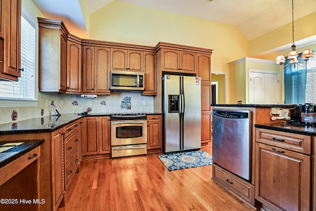 1711 Heather Run Ct SE, Bolivia, NC 28422 - kitchen with stainless steel appliances, light wood-style floors, a chandelier, pendant lighting, and decorative backsplash