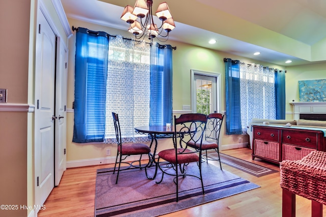 1711 Heather Run Ct SE, Bolivia, NC 28422 - dining space featuring a chandelier, wood finished floors, baseboards, recessed lighting, and a fireplace