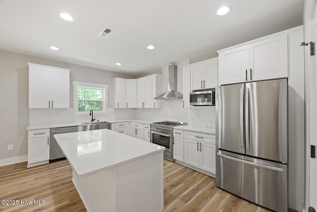 189 Craven Ct, Calabash, NC 28467 - kitchen featuring stainless steel appliances, wall chimney range hood, a sink, a kitchen island, and white cabinets