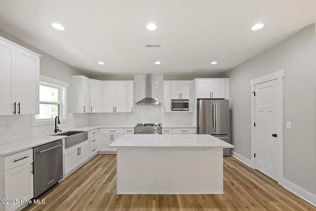 189 Craven Ct, Calabash, NC 28467 - kitchen with appliances with stainless steel finishes, wall chimney exhaust hood, a sink, a center island, and tasteful backsplash